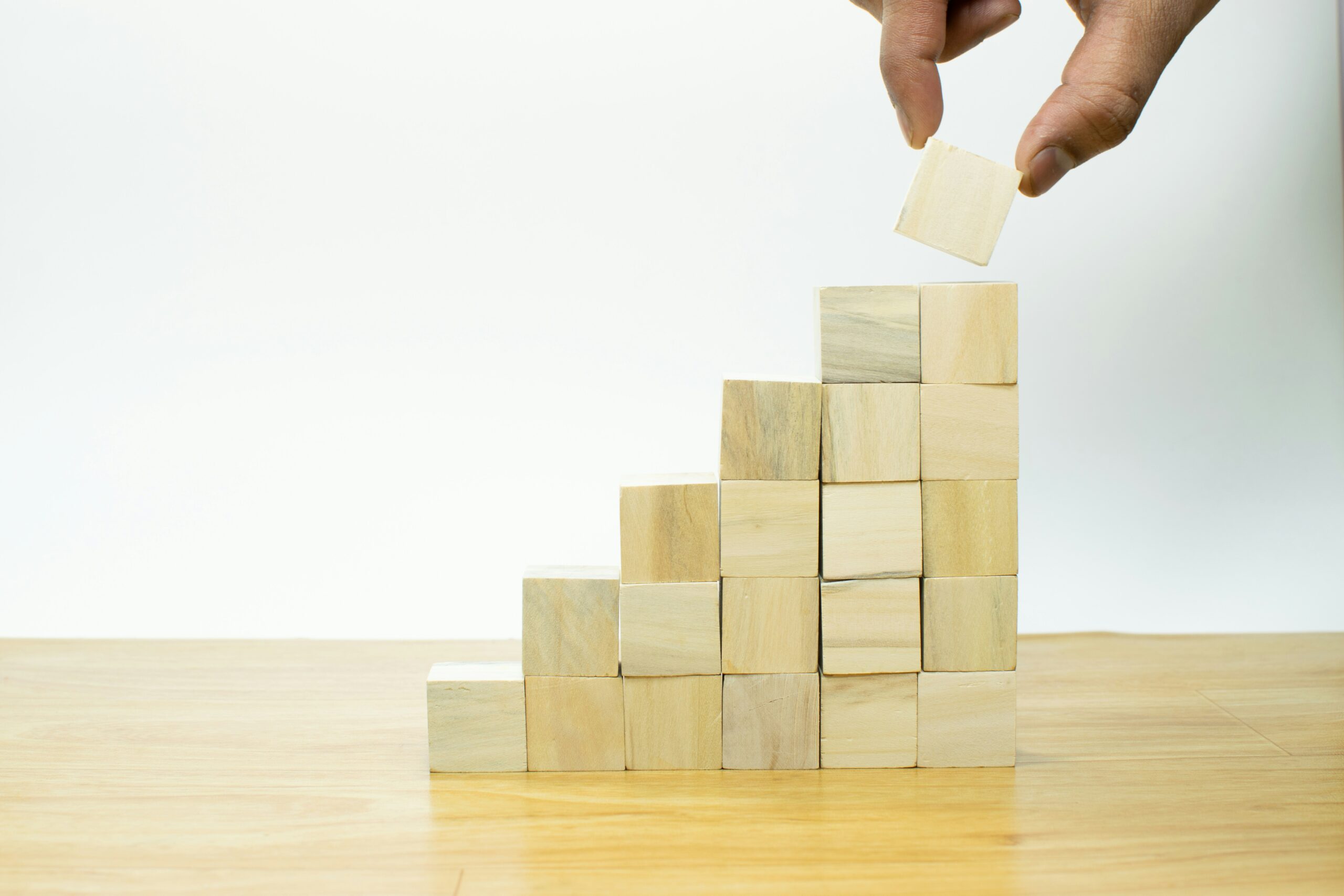 a person placing a piece of wood into a pyramid