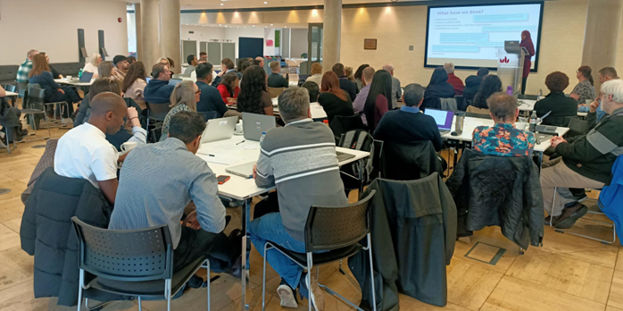 Image showing Luton Council’s DDaT service at our third ‘away day’, with Director of Digital, Data and Technology, Atika Mohammed, on stage during the opening introduction.