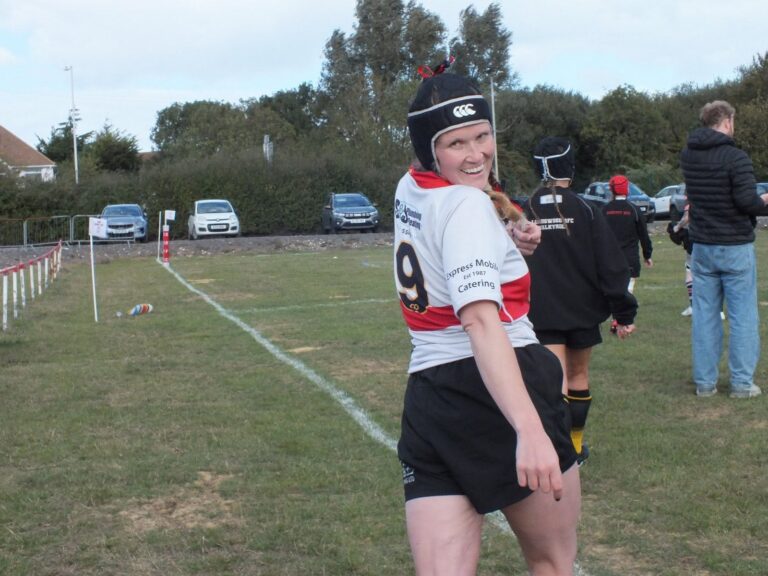 Photo of Rebecca McCraken, dressed in sports attire on a rugby field.